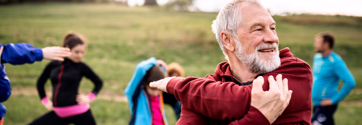 Adulto mayor estirando sus músculos al aire libre