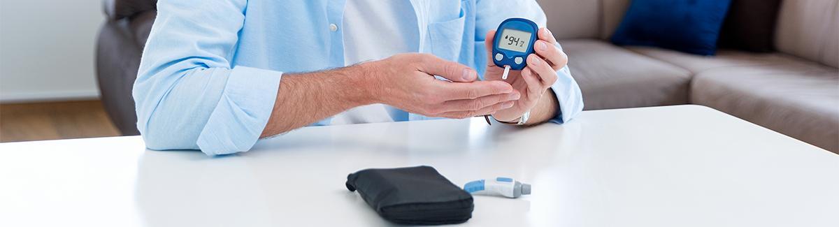 Hombre tomando prueba de sangre con glucómetro 