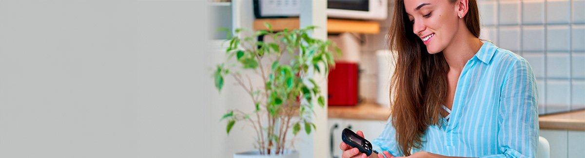 Mujer joven, tranquila, monitoreándose la glucosa en la sangre.