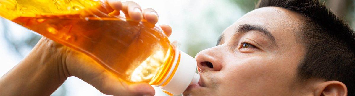 Persona hidratándose antes, durante o después de realizar una actividad física.