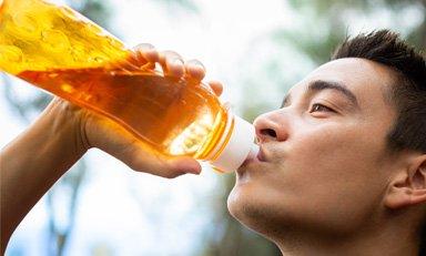 Persona hidratándose antes, durante o después de realizar una actividad física.