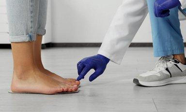 ”Doctor tocando un dedo del pie de una paciente"