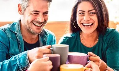 Grupo de amigos felices brindan con tazas de café