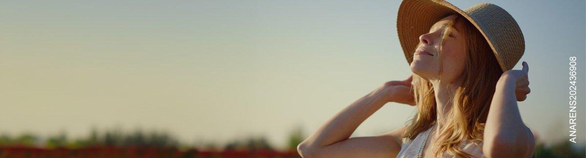  Mujer con los ojos cerrados y sombrero disfruta del atardecer