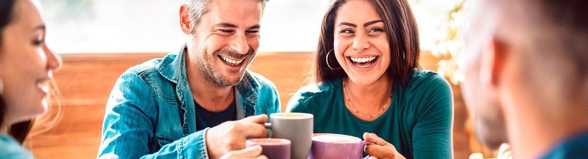 Grupo de amigos felices brindan con tazas de café