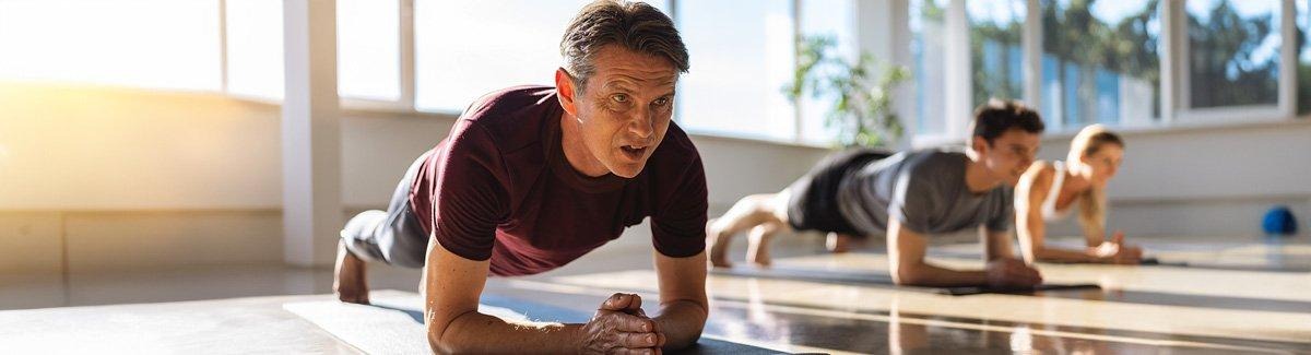 Grupo de personas en un gimnasio practica yoga.