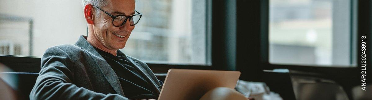  Hombre adulto sonriendo frente al computador