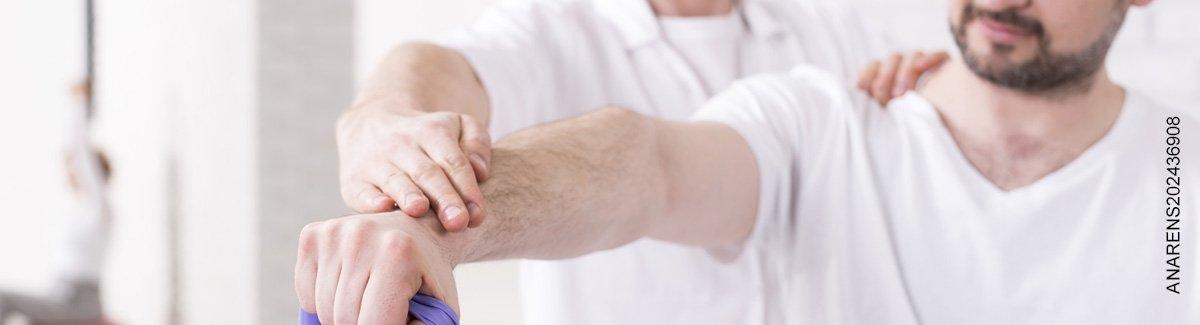 Hombre estira su brazo con ayuda de otra persona