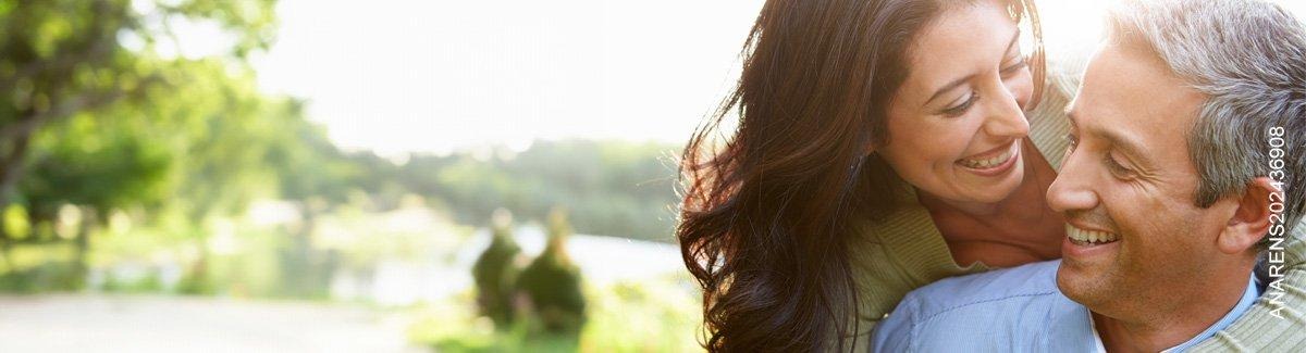  Mujer abraza a su esposo por la espalda sonriendo