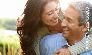  Mujer abraza a su esposo por la espalda sonriendo