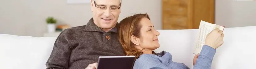 Hombre y mujer en sofa leyendo