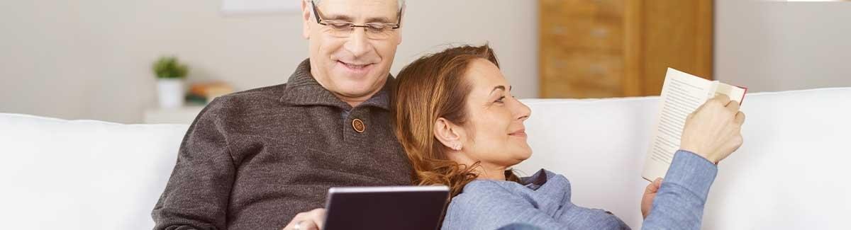 Hombre y mujer en sofa leyendo